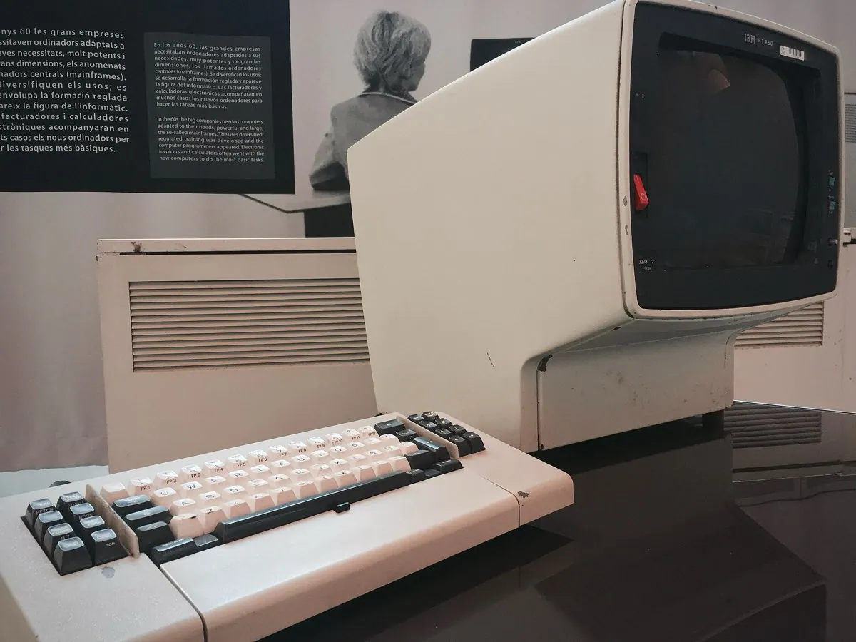 An IBM 3278 terminal from the early 1980s, a boxy beige monitor showing green text on a black screen, with an attached keyboard.