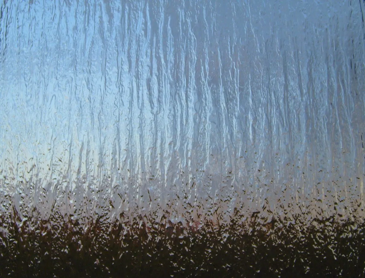 A sheet of frosted, opaque glass. Light passes through it but shapes behind it are softened into blur.