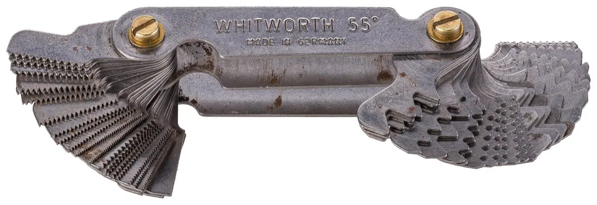 A thread pitch gauge fanned open, its leaves cut to check Whitworth and metric screw threads.